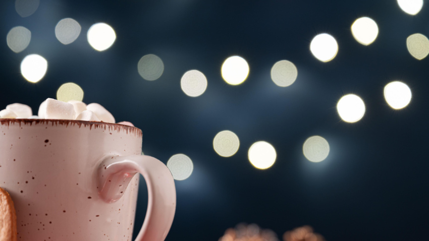 2GP0G3H Top of a coffee or cocoa mug heaping with mini marshmallows in a holiday setting with christmas lights in background.