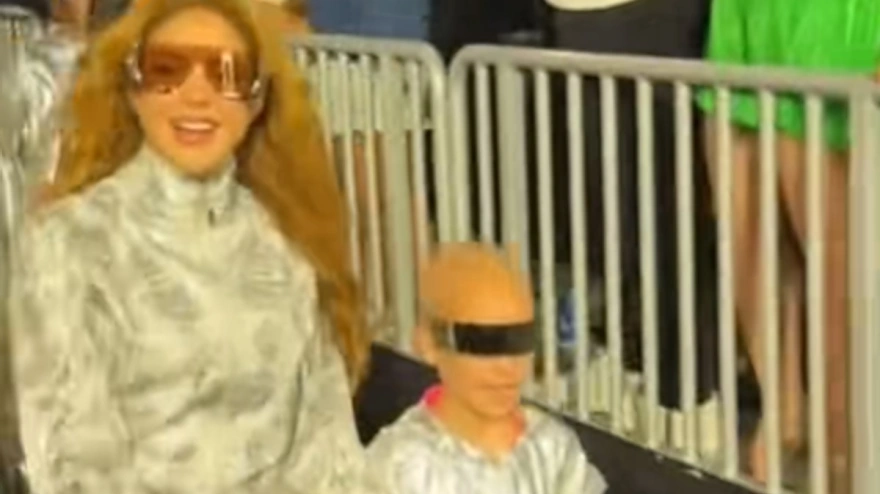 Shakira camina de la mano de una niña con cáncer a su entrada al concierto en Miami